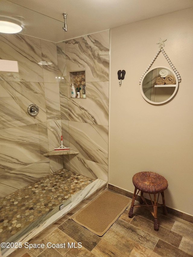 bathroom featuring a shower, wood finished floors, and baseboards