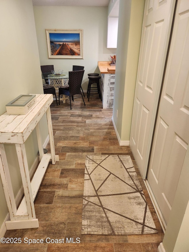 home office with baseboards and wood finished floors