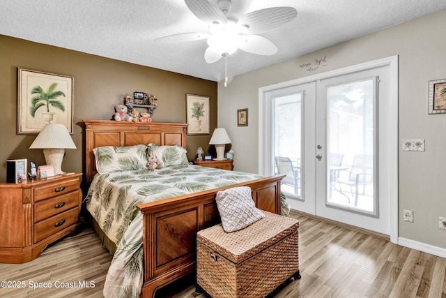 bedroom with light wood-type flooring, access to exterior, a textured ceiling, and french doors