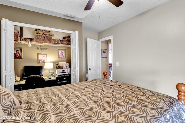 bedroom featuring a ceiling fan, a textured ceiling, visible vents, and a closet