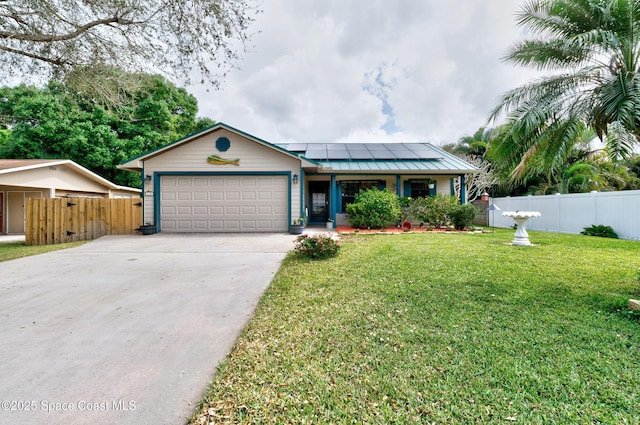 single story home featuring an attached garage, a front yard, roof mounted solar panels, fence, and driveway