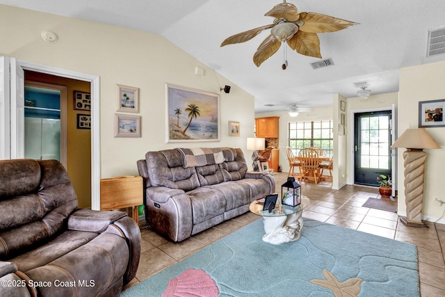 living area featuring a ceiling fan, visible vents, vaulted ceiling, and light tile patterned floors