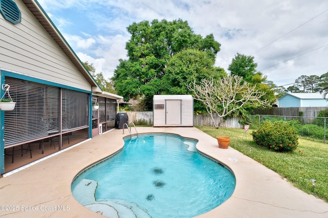 view of swimming pool featuring an outbuilding, a fenced backyard, a lawn, and a shed