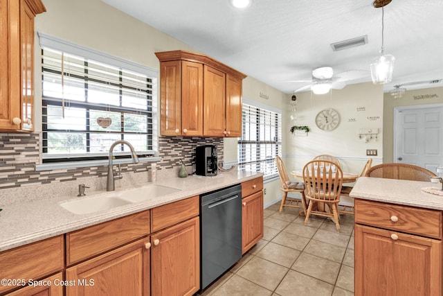 kitchen featuring a wealth of natural light, light countertops, a sink, and stainless steel dishwasher