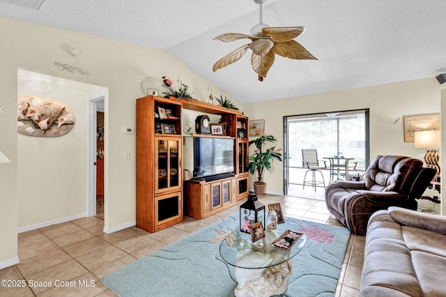living area with ceiling fan, vaulted ceiling, a textured ceiling, and light tile patterned floors