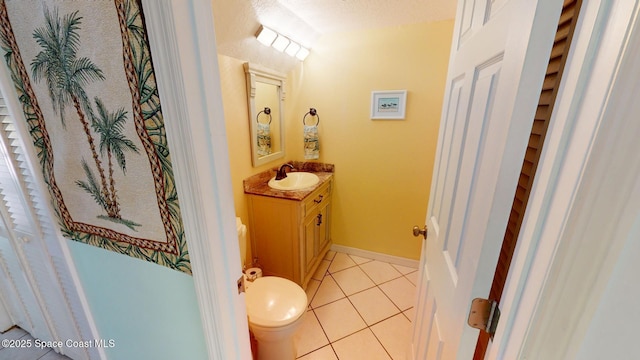 bathroom featuring tile patterned floors, toilet, vanity, and baseboards