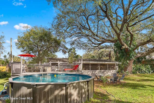 view of swimming pool featuring a sunroom, a yard, and a deck