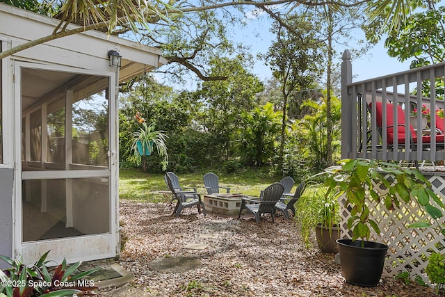 view of yard featuring an outdoor fire pit and a sunroom