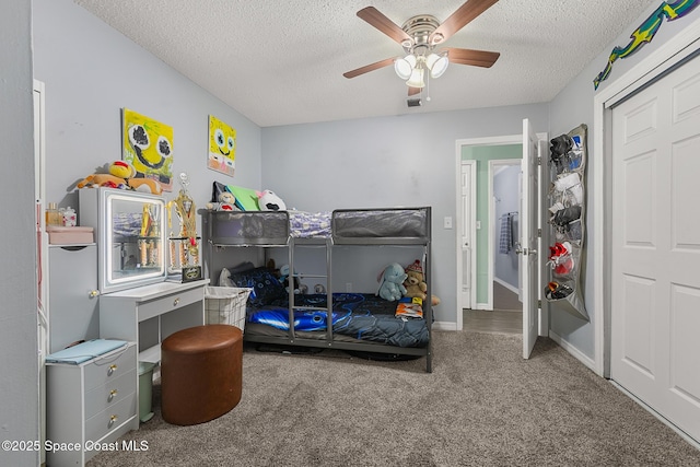 carpeted bedroom with baseboards, visible vents, ceiling fan, and a textured ceiling