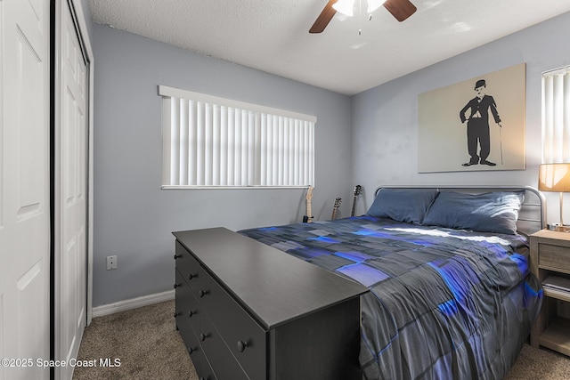 bedroom with carpet floors, a textured ceiling, baseboards, and a ceiling fan