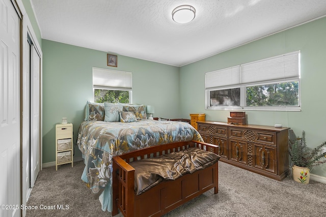 carpeted bedroom with a closet, baseboards, and a textured ceiling