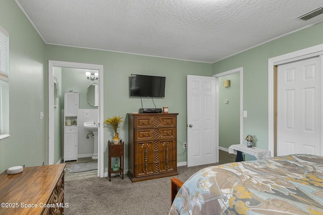 bedroom featuring a textured ceiling, carpet flooring, visible vents, baseboards, and a closet