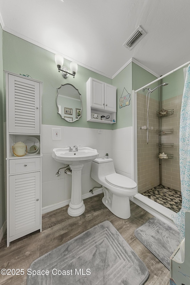 full bath with toilet, a stall shower, visible vents, and wood finished floors