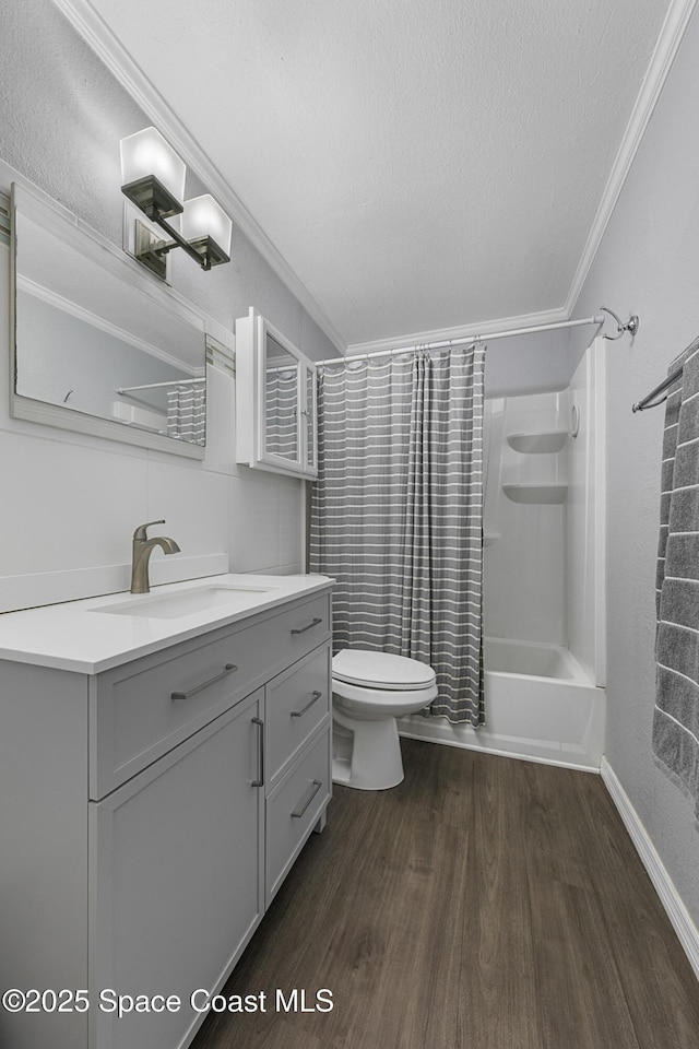 bathroom featuring toilet, ornamental molding, wood finished floors, a textured ceiling, and vanity