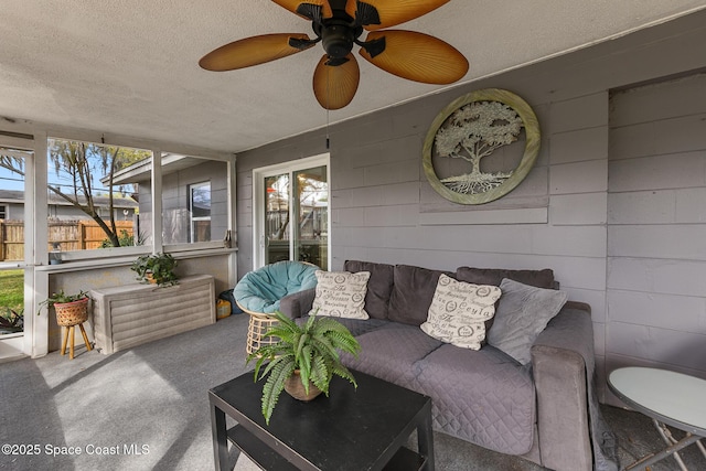 living area featuring a textured ceiling, ceiling fan, and carpet flooring