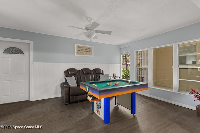 playroom featuring a ceiling fan, a wainscoted wall, a textured ceiling, and wood finished floors