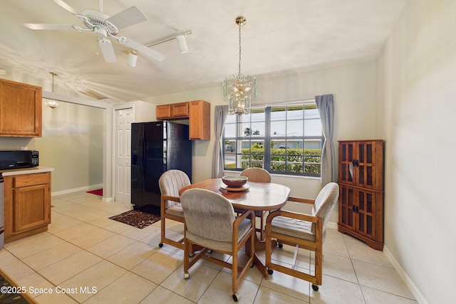 dining area featuring light tile patterned floors, ceiling fan with notable chandelier, lofted ceiling, and baseboards