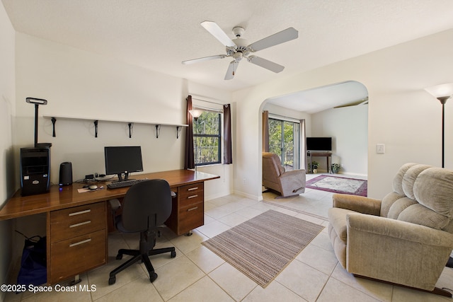 office featuring arched walkways, ceiling fan, a textured ceiling, and light tile patterned floors