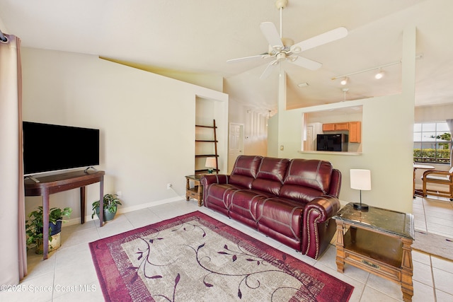 tiled living room featuring vaulted ceiling, track lighting, a ceiling fan, and baseboards