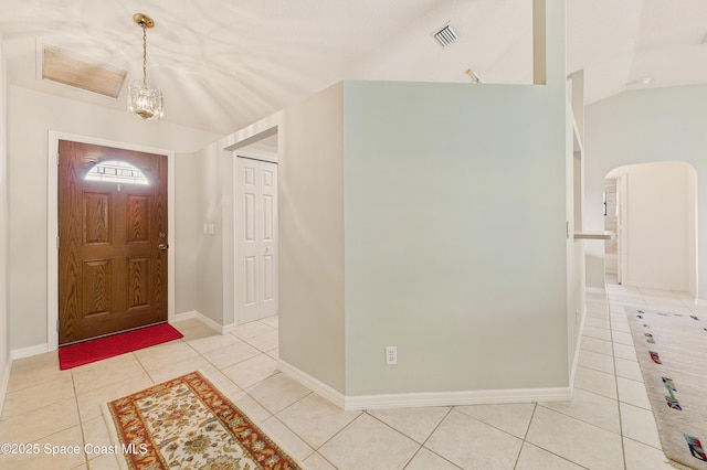 entrance foyer with lofted ceiling, light tile patterned flooring, visible vents, and baseboards