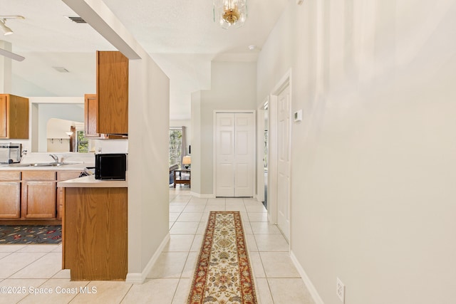 interior space featuring light tile patterned floors, light countertops, visible vents, and brown cabinets