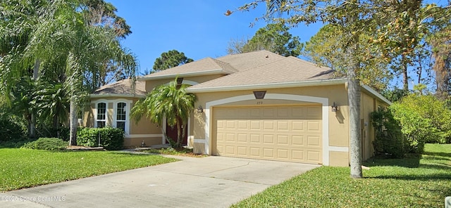 view of front of house featuring an attached garage, concrete driveway, roof with shingles, stucco siding, and a front yard