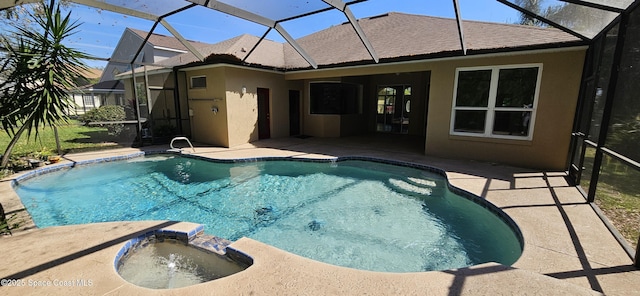 view of swimming pool featuring glass enclosure, a patio area, and a pool with connected hot tub