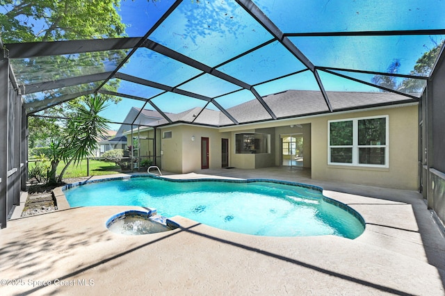 view of pool with glass enclosure, a pool with connected hot tub, and a patio