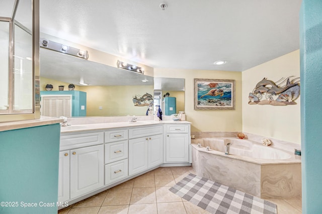 bathroom with tile patterned flooring, a garden tub, a sink, and double vanity