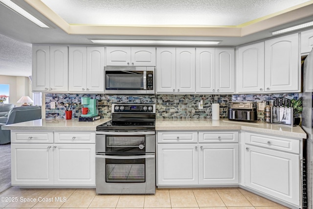 kitchen featuring stainless steel appliances, white cabinets, light countertops, and light tile patterned floors