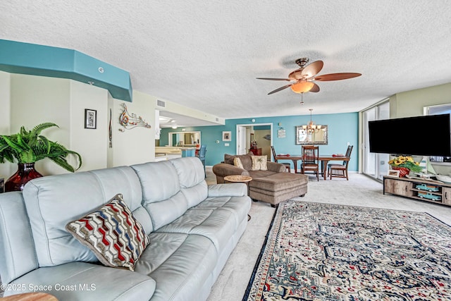 carpeted living area featuring visible vents, a textured ceiling, and ceiling fan with notable chandelier