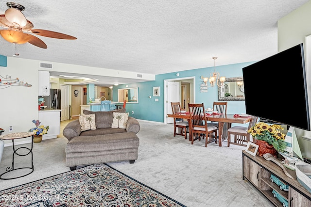 living area featuring light carpet, baseboards, visible vents, a textured ceiling, and ceiling fan with notable chandelier