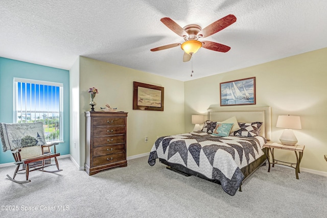 carpeted bedroom with a ceiling fan, a textured ceiling, and baseboards