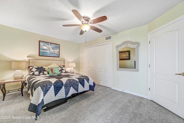 bedroom with carpet floors, a closet, visible vents, and a textured ceiling