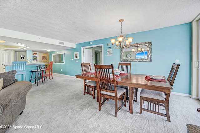 dining area with baseboards, a textured ceiling, visible vents, and carpet flooring