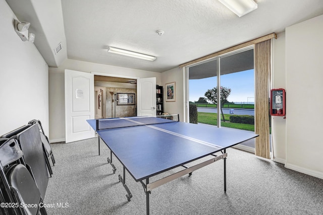 rec room with carpet floors, visible vents, a textured ceiling, and baseboards