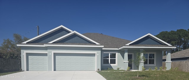 craftsman-style home featuring concrete driveway, an attached garage, fence, a front lawn, and stucco siding