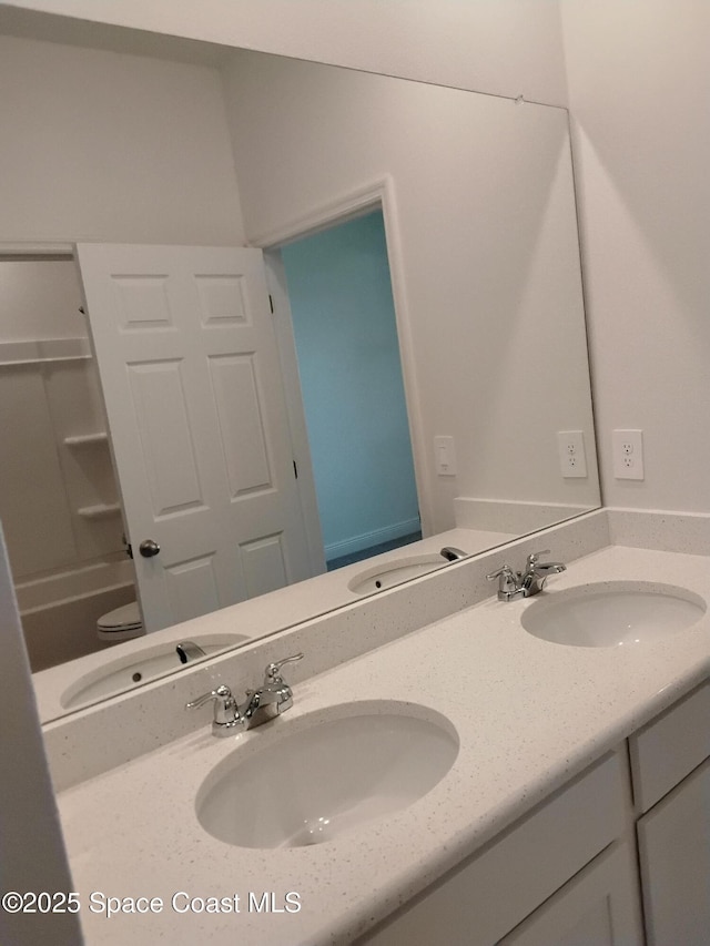 full bathroom with double vanity and a sink