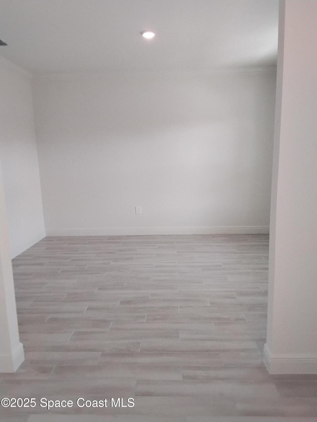 unfurnished room with baseboards, wood finished floors, and recessed lighting