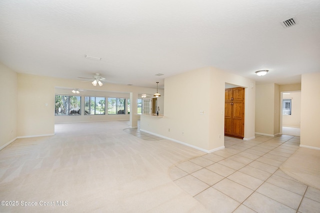 spare room featuring light tile patterned floors, a textured ceiling, light colored carpet, visible vents, and baseboards