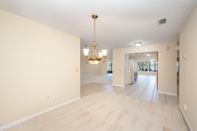 spare room with light tile patterned floors, visible vents, light carpet, a textured ceiling, and a chandelier