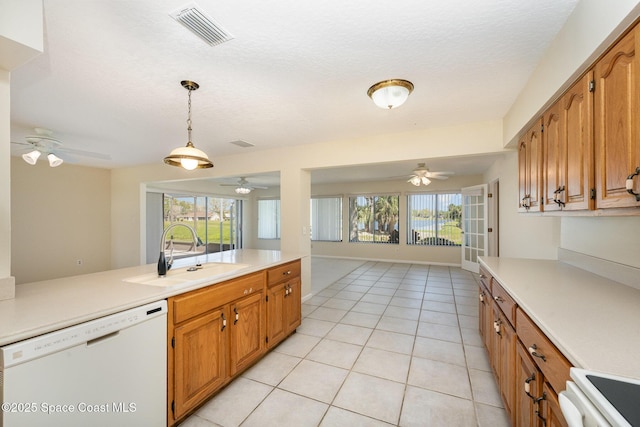 kitchen with visible vents, range, open floor plan, white dishwasher, and a sink