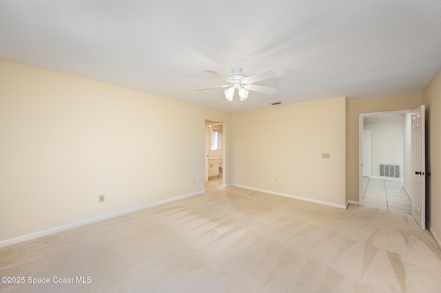 empty room with visible vents, ceiling fan, light carpet, and baseboards