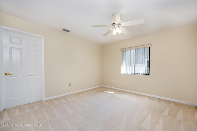 unfurnished room with light carpet, ceiling fan, visible vents, and baseboards