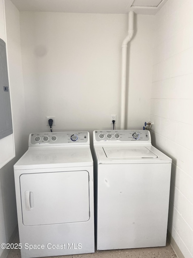 laundry room with concrete block wall, laundry area, and washing machine and clothes dryer