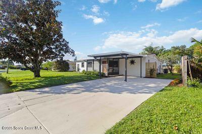 single story home with concrete driveway and a front lawn