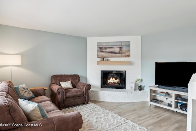 living area with a large fireplace and wood finished floors