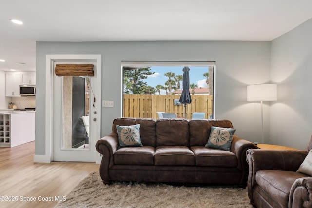 living area with light wood finished floors and recessed lighting