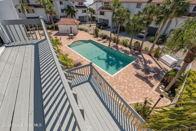 community pool featuring a grill, fence, and a patio