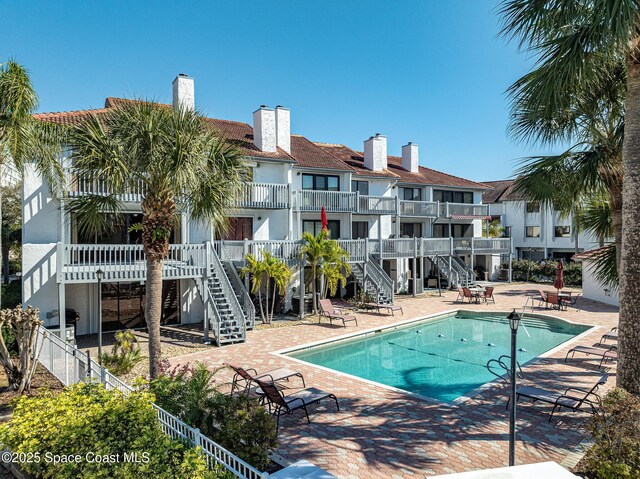 pool with a patio area, fence, stairway, and a residential view